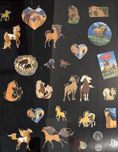 Collection of enamel pins and buttons featuring horses from "Spirit: Stallion of the Cimarron."